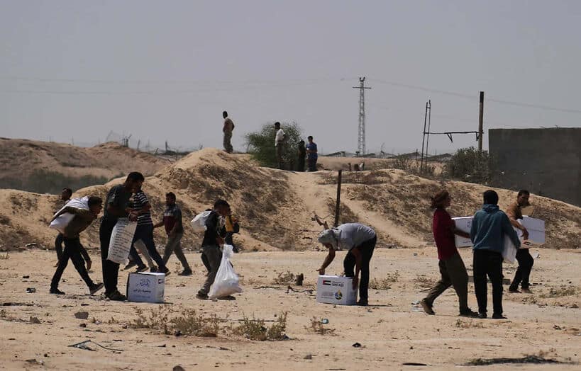 Palestinians collect humanitarian aid packages from the United Arab Emirates after they were airdropped into Deir al-Balah, in central Gaza Strip, Saturday, Aug. 9, 2025.