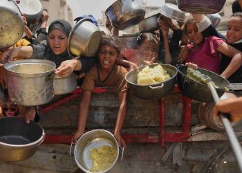Palestinians struggle to get donated food at a community kitchen in Gaza City, northern Gaza Strip, Aug. 16, 2025.