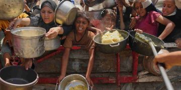 Palestinians struggle to get donated food at a community kitchen in Gaza City, northern Gaza Strip, Aug. 16, 2025.