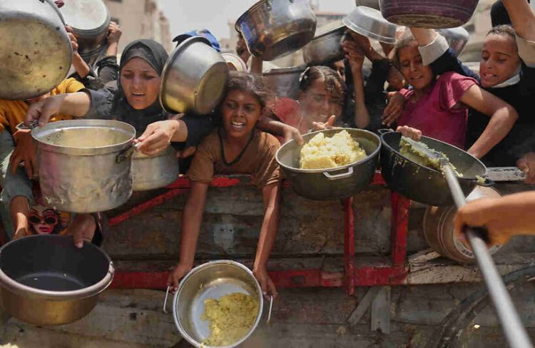 Palestinians struggle to get donated food at a community kitchen in Gaza City, northern Gaza Strip, Aug. 16, 2025.