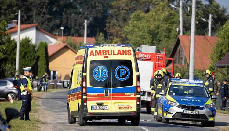 An ambulance drives past a police officer and firefighters after an apparent Russian drone struck a residential building, according to local authorities, following violations of Polish airspace during a Russian attack on Ukraine, in Wyryki municipality, Poland, Sept. 10, 2025.