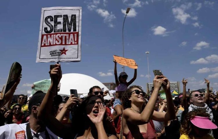 Activists chant "No amnesty" during a protest against an amnesty bill that could absolve former President Jair Bolsonaro and his allies convicted for a 2023 coup attempt, in Brasilia, Brazil, Sunday, Sept. 21, 2025.